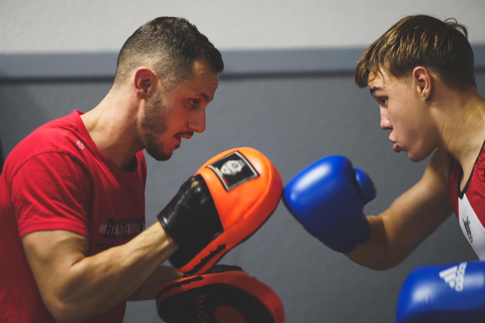 Boxe ados à Blagnac : un entraîneur tient les pattes d’ours, un jeune boxeur enchaîne au gant bleu
