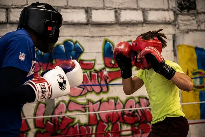 Boxe enfant à Blagnac : un jeune boxeur casqué, gants rouges, garde haute face à son partenaire